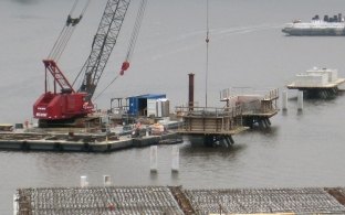 A crane on a barge in the water during construction