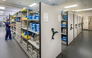 View of a stocked supply storage area with multiple shelving units.