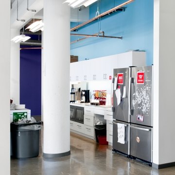 A kitchen area inside of an office space. 