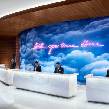 People working at the front desk of the resort with art on the wall in the background