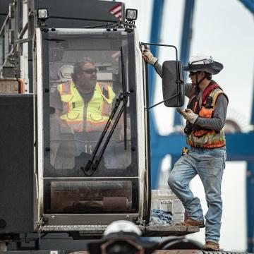 Employees talking to each other on equipment