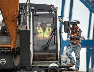 Employees talking to each other on equipment