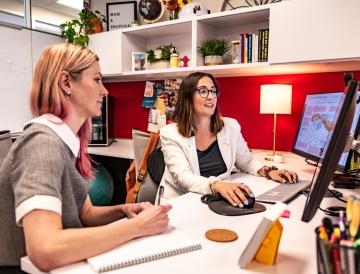 Two people sitting at a desk.