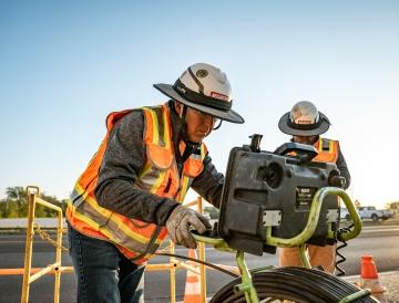 Two people working with a piece of equipment