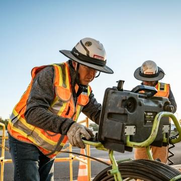 Two people working with a piece of equipment