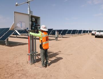 A person looking at an electrical component of a renewable energy project