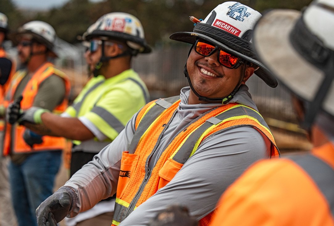 A person smiling while wearing PPE on the jobsite
