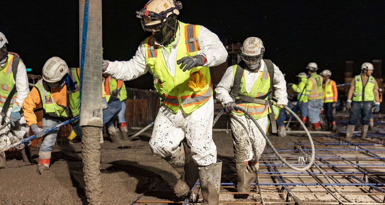 A group of people working on a concrete pour at night
