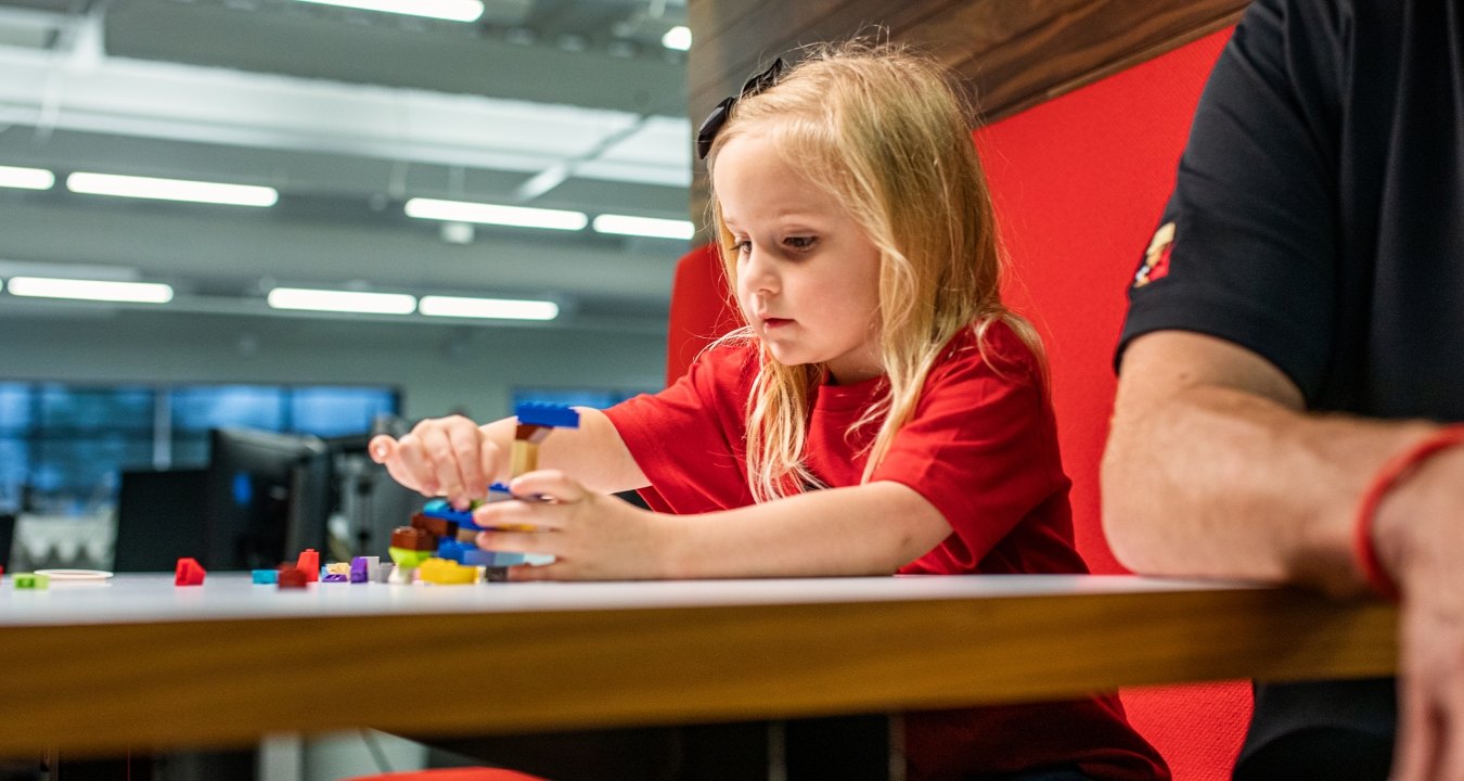 A child building with Legos at the table