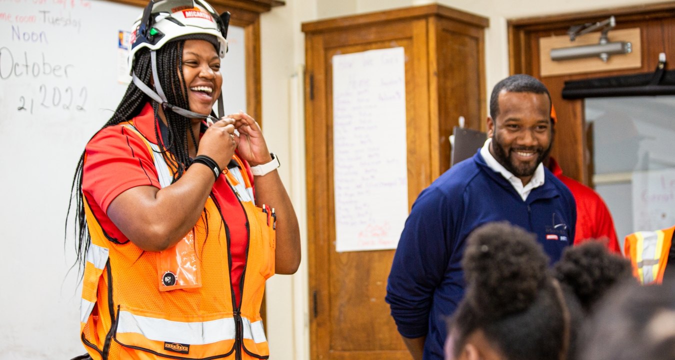 a construction worker speaking to students