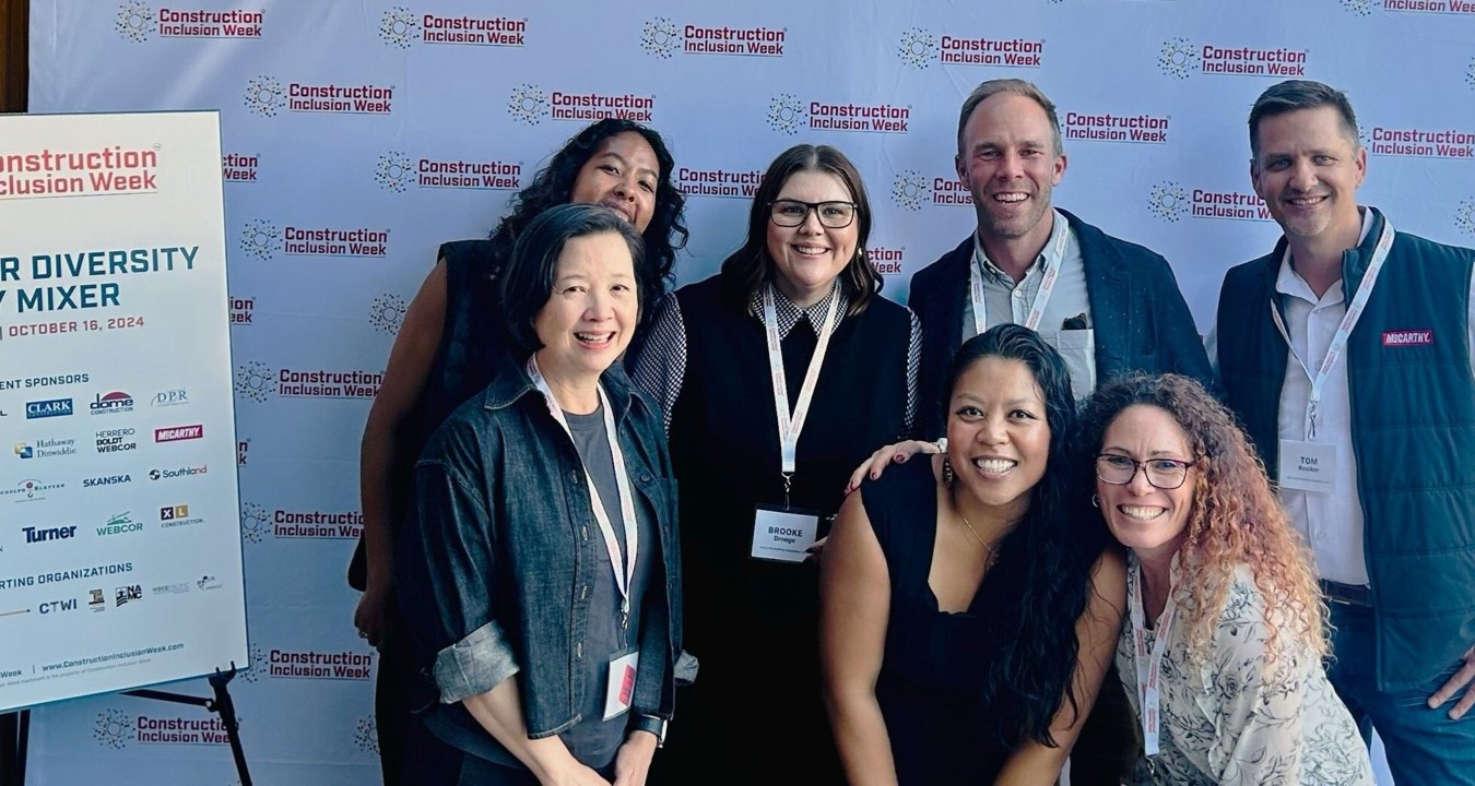 Group of people posing in front of a Construction Inclusion Week banner.