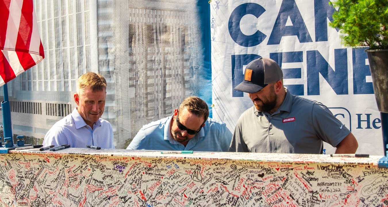 people signing a beam at a topping out ceremony