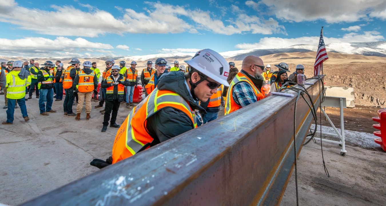Construction workers prepare steel beam.