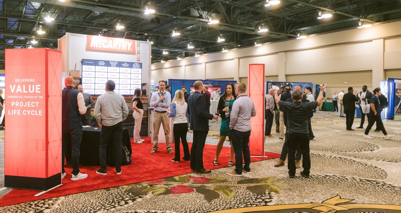 A group of people at McCarthy's DBIA booth in 2024. 