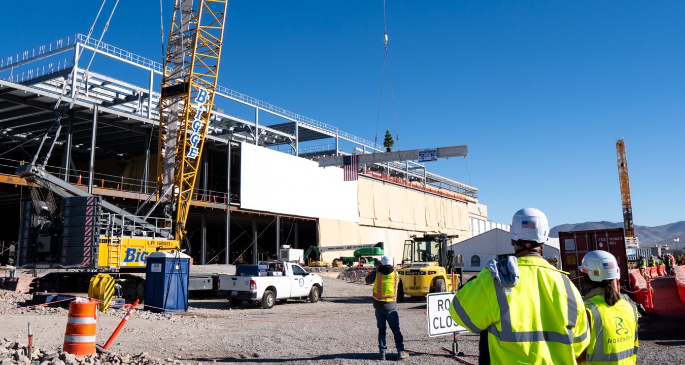 A couple of people standing in front of a building under construction