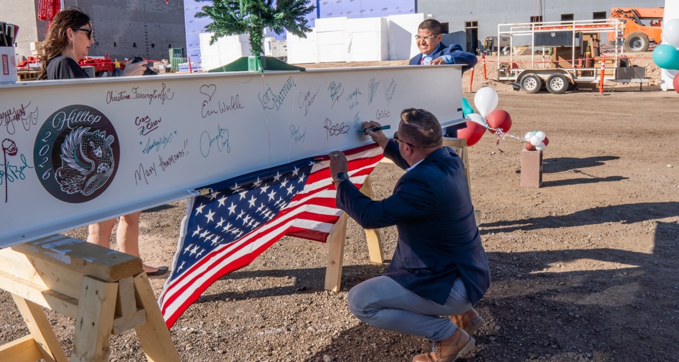 People signing a beam