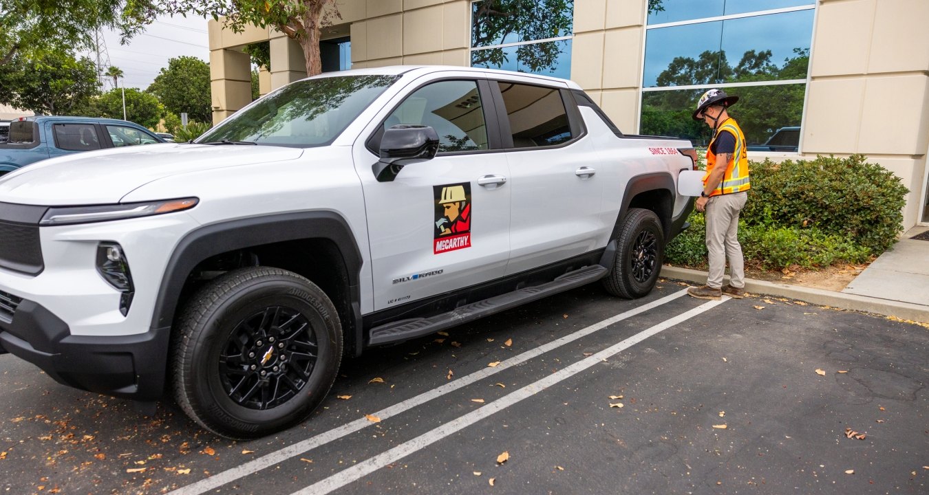 A person using a charger on an electric vehicle