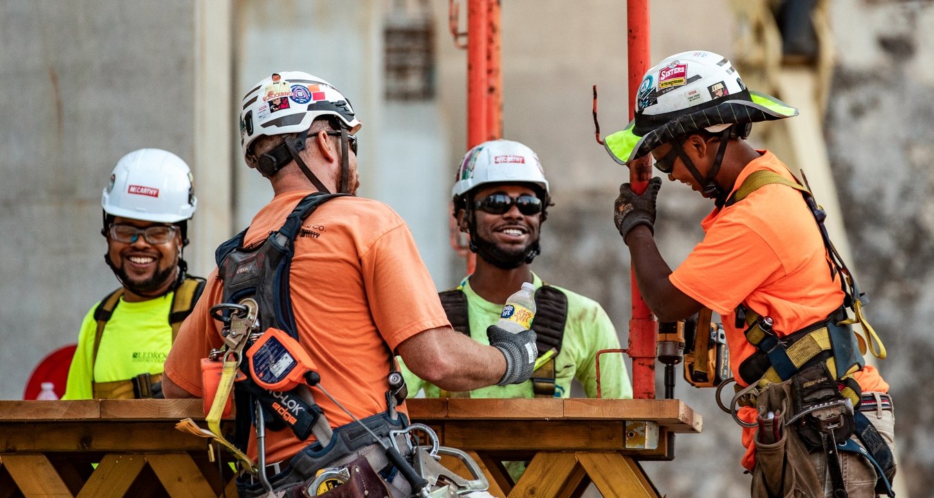 Four people wearing PPE working together on a jobsite