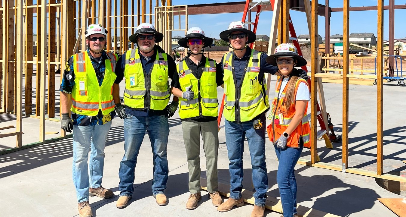 A group of five people wearing PPE on a jobsite