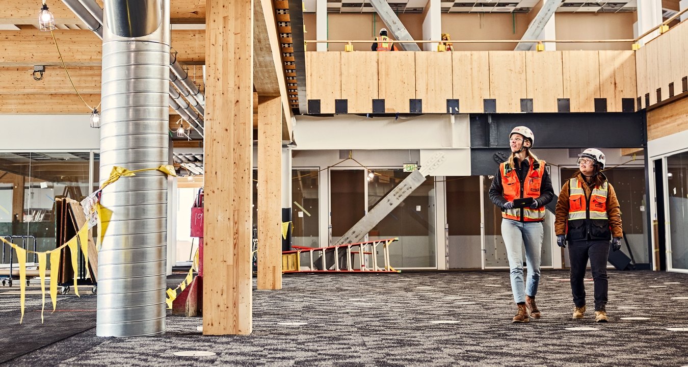 Two people wearing PPE walking through a jobsite
