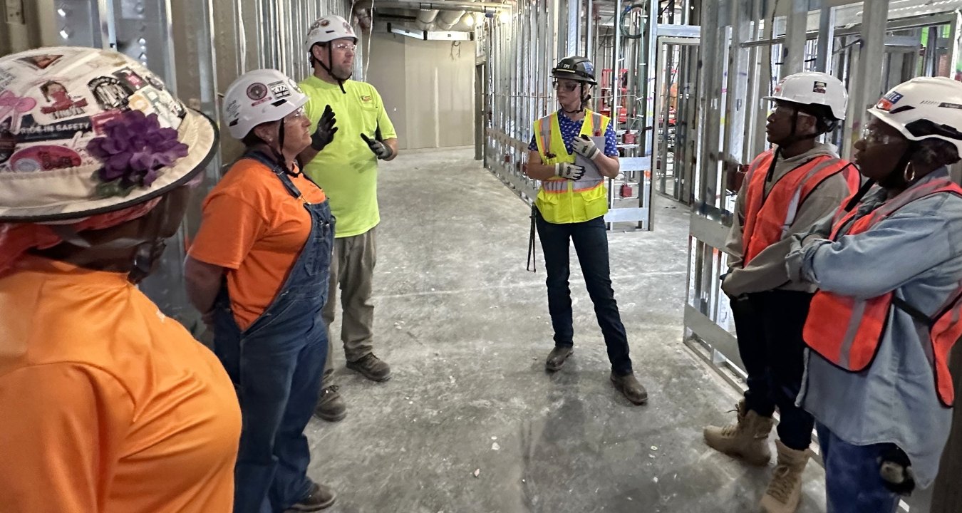 A group of people wearing PPE and talking while on a jobsite