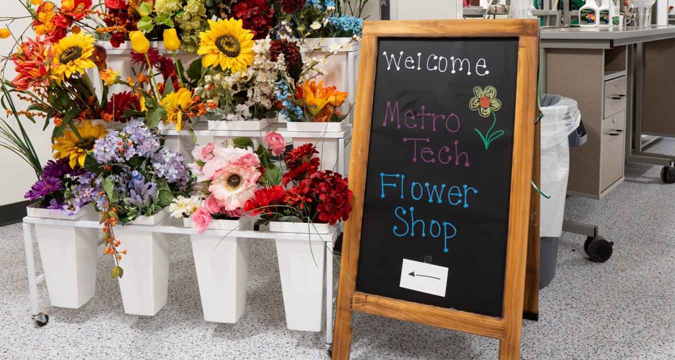 A welcome sign next to some flowers