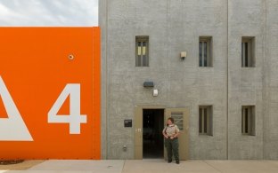 Housing and Healthcare Facility Stockton with Large 4 Graphic on Building and Guard at Building Door