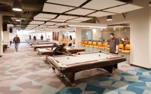 A recreation area with people using pool tables