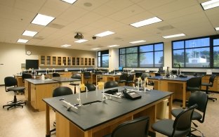 Classroom with rectangular tables and chairs. 