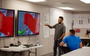 Employees looking at screen in trailer