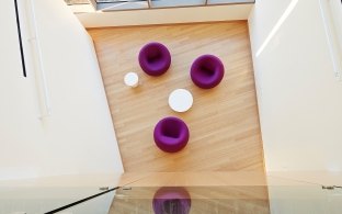 A stylish meeting nook at the J. Craig Venter Genome Lab with purple puff chairs.