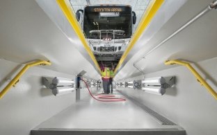 San Joaquin Regional Transit District underground bus maintenance bay with mechanics working