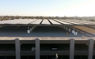 The parking structure includes rooftop PV solar panels.