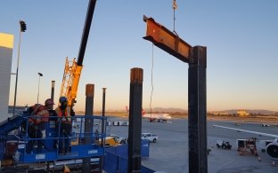 Iron workers installing steel beams at delta airlines enabling project