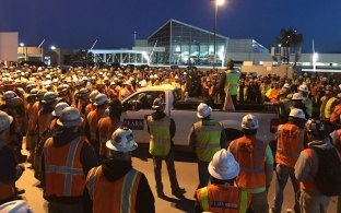 Delta Enabling Project construction workers surrounding pickup truck