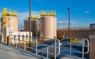 Beige-colored holding tanks at a water treatment facility.