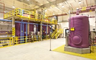 Purple holding tanks inside the large and industrial-looking water treatment plant.