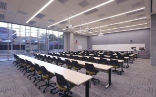 Lecture / presentation room with long tables and chairs.