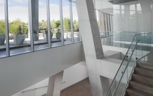 Marble-tone stairs and white walls lined by glass walls at the ASU Biodesign Institute.