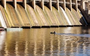 Two construction workers in boat on water near Ameren Bagnell Dam