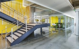 An interior staircase with a yellow wall