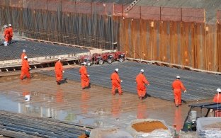 Outdoor close up image of workers in jumpsuits building