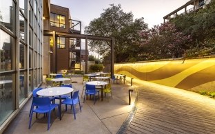 An outdoor seating area with tables and blue chairs