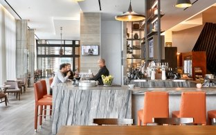 Indoor dining area with orange chairs and stone countertops