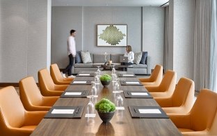 Indoor board room with orange chairs and a wood table