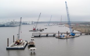Aerial view of multiple cranes on barges on the water during construction