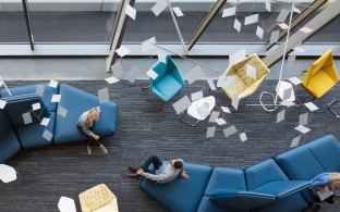 Two people sitting on couches talking.