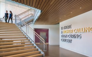 Two people walking down the stairs at the Knight Cancer Institute.