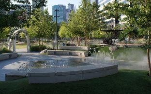 A fountain and water area with benches on the edge