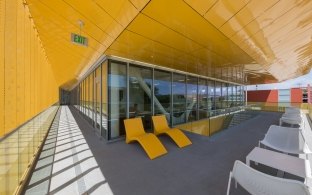 Outdoor covered patio with a yellow ceiling and white chairs